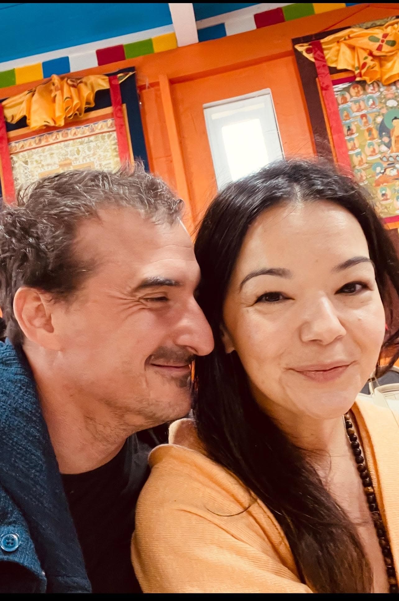 Tom and his wife, Barine, together in a colorful room