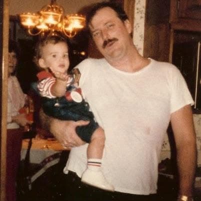 Tom’s father holding young Tom beneath a chandelier