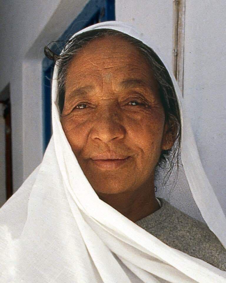 Portrait of a woman wearing a white headscarf.