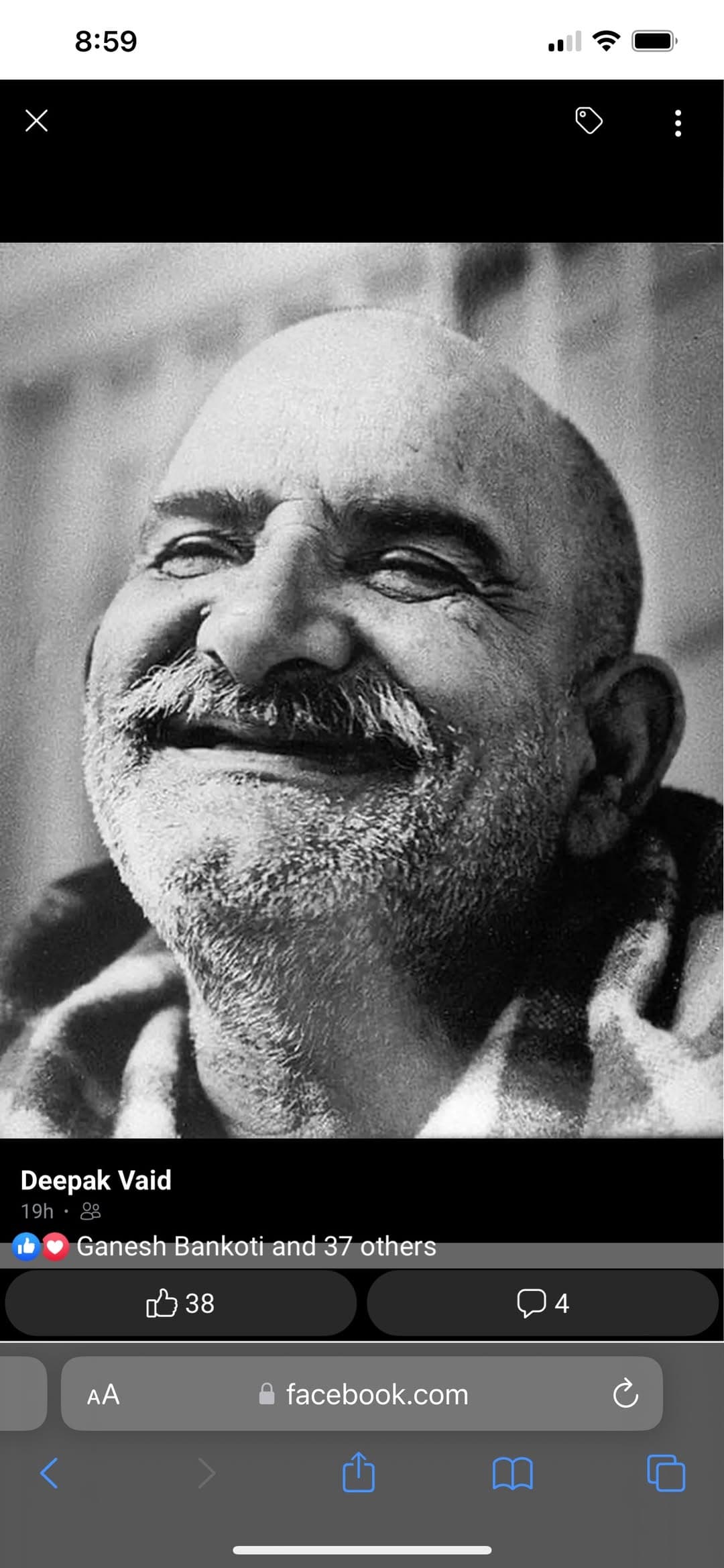 Facebook screenshot of a black-and-white portrait of Neem Karoli Baba smiling with his eyes closed.