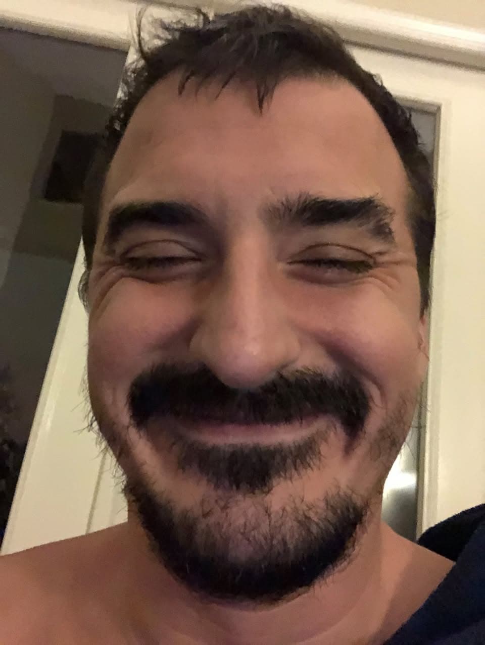 Close selfie of Thomas Whigham with a mustache and goatee, eyes crinkled in a smile.